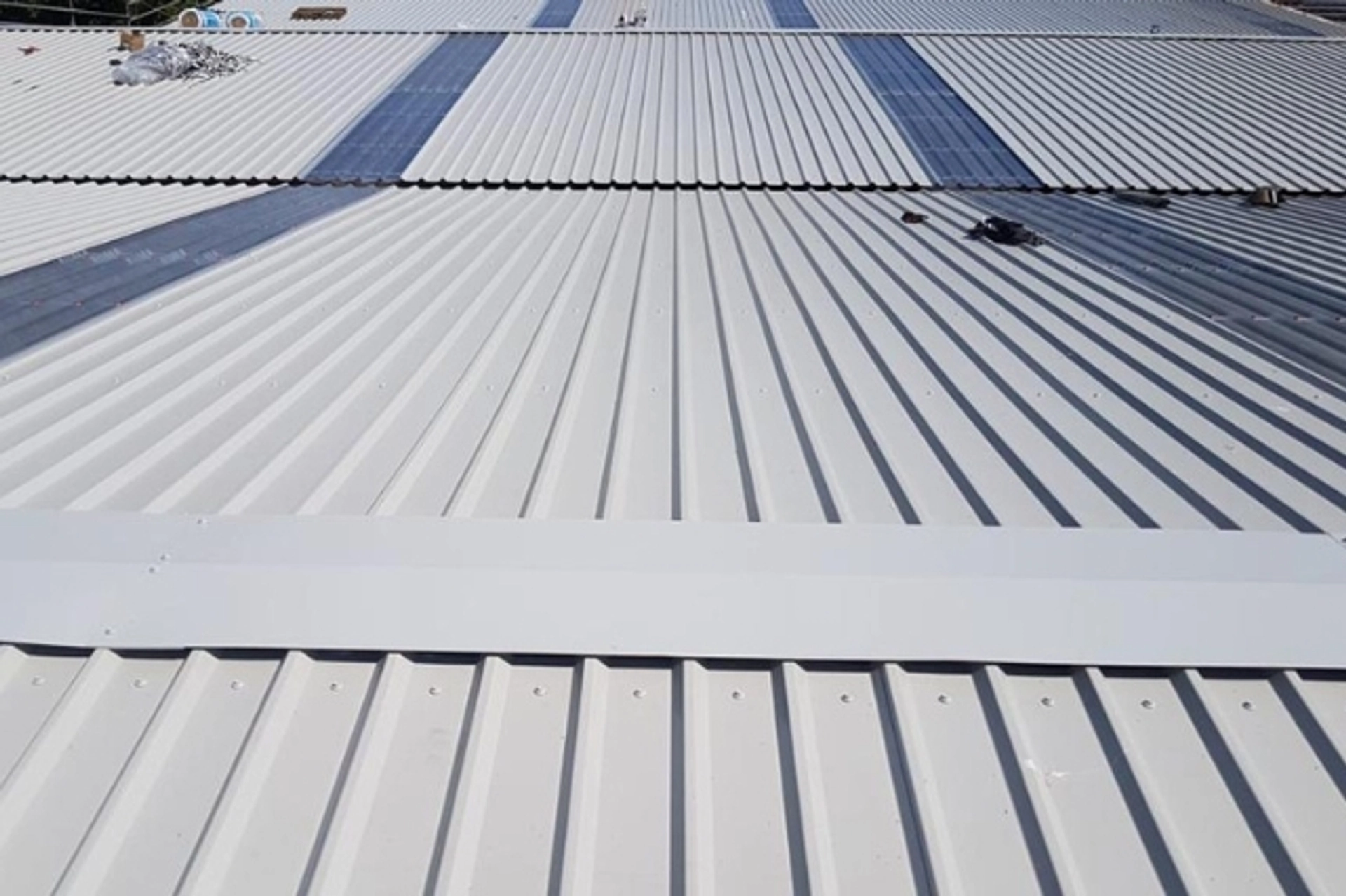 Over-cladding in progress on a metal roof